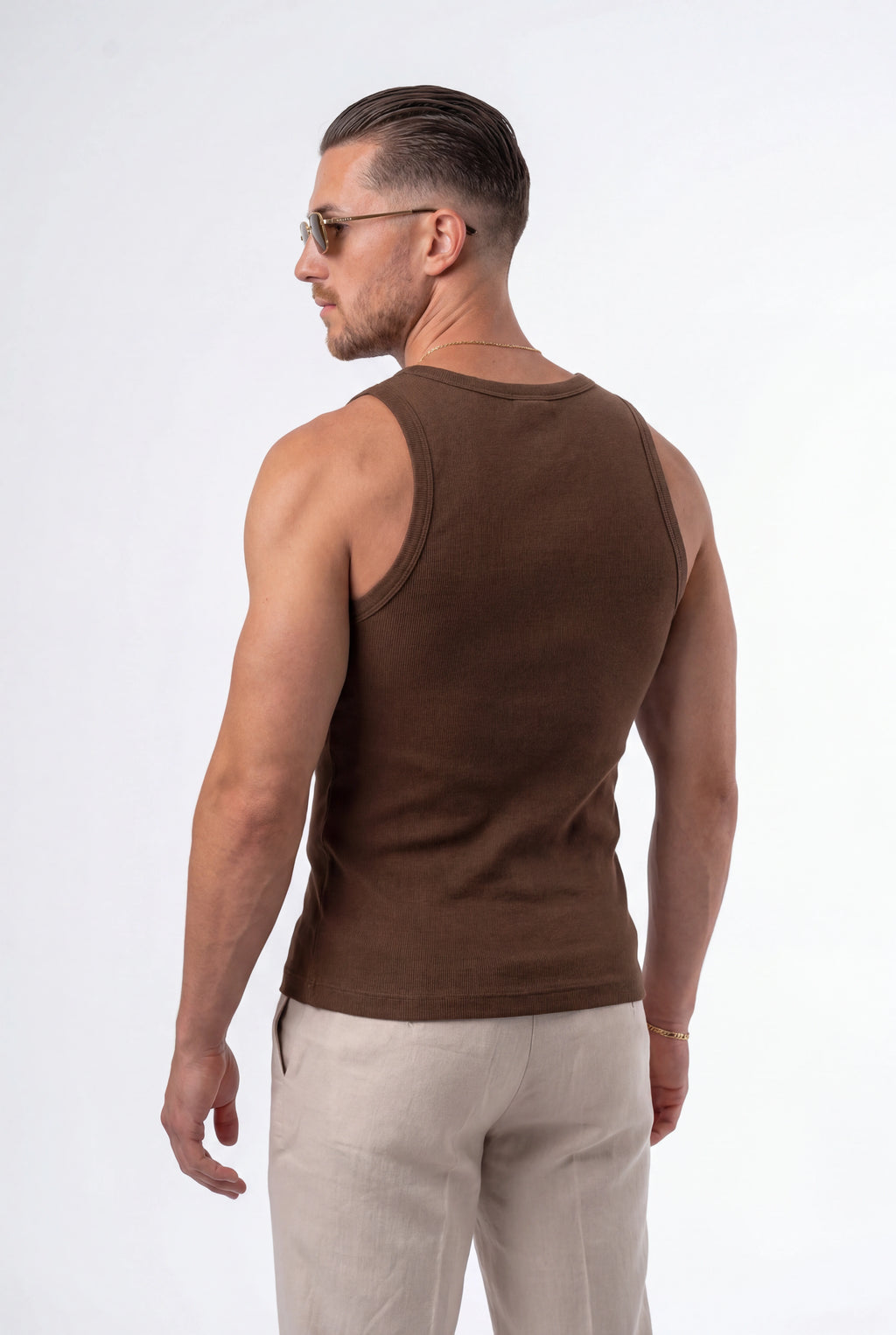 [Chocolate] Man wearing a brown tank top and light-colored pants on a white background