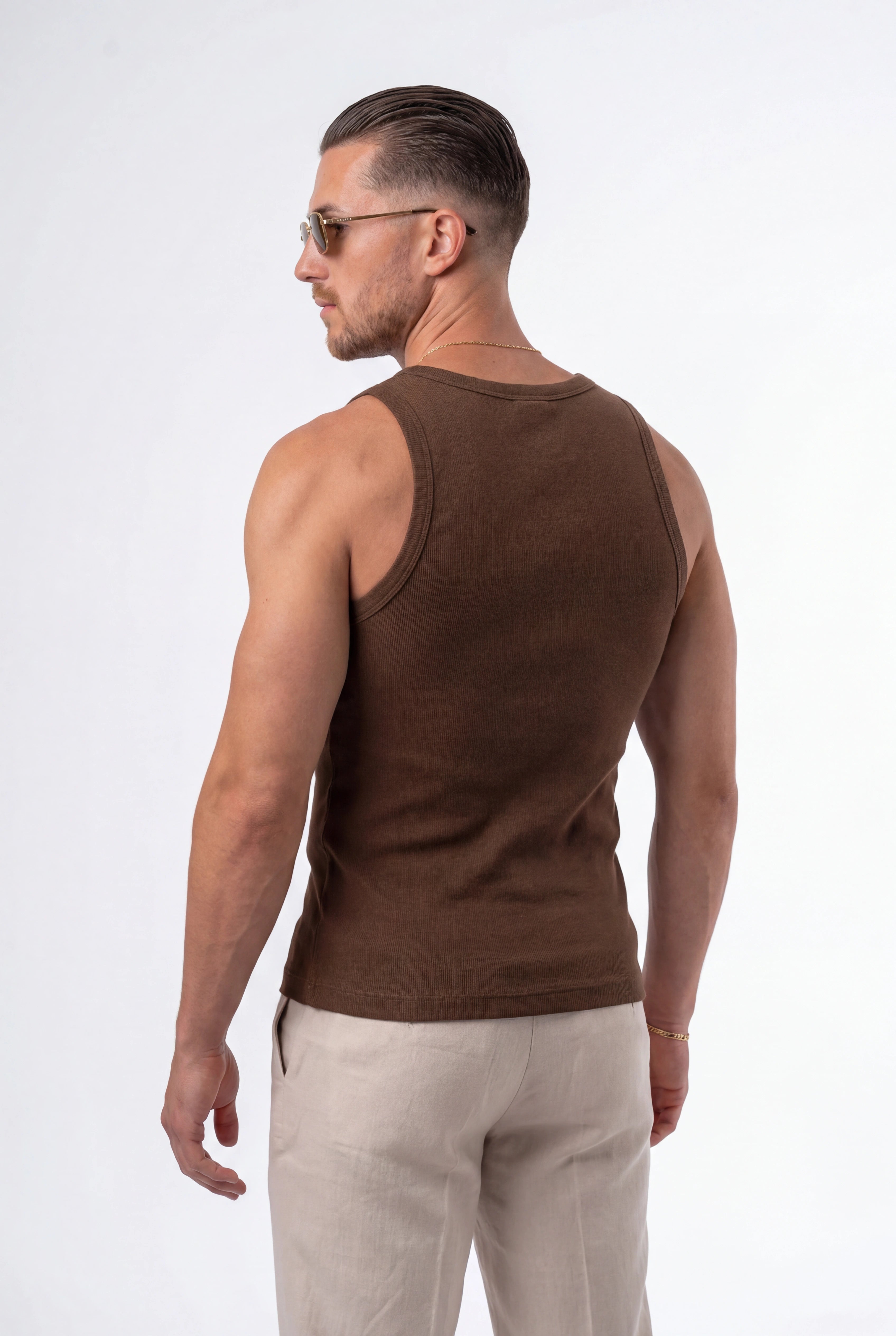 [Chocolate] Man wearing a brown tank top and light-colored pants on a white background