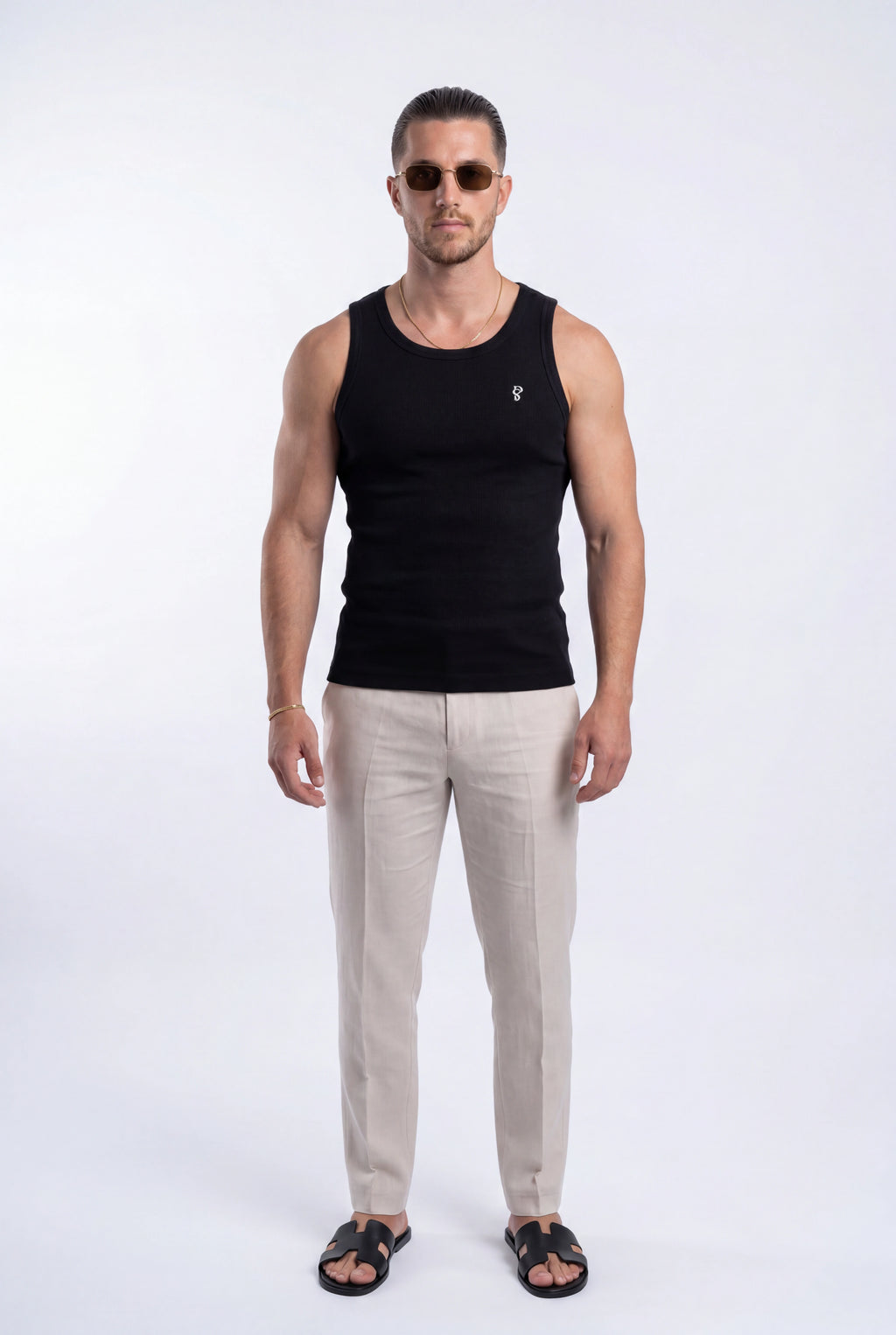 [Black] Man wearing a black tank top and beige pants on a white background