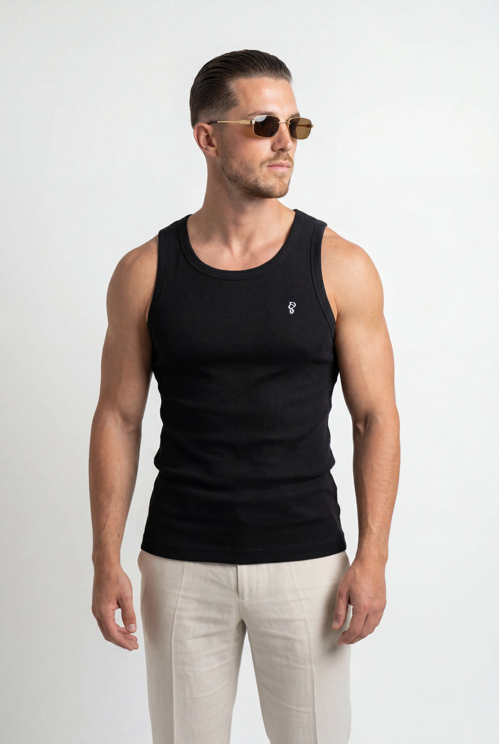 [Black] Man wearing a black tank top and light-colored pants on a white background