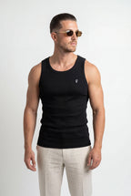 [Black] Man wearing a black tank top and light-colored pants on a white background