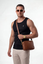 [Black] Man wearing sunglasses and a black tank top, holding a brown leather bag on a white background