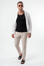 [Black] Man wearing a light gray shirt over a black t-shirt and beige pants on a white background