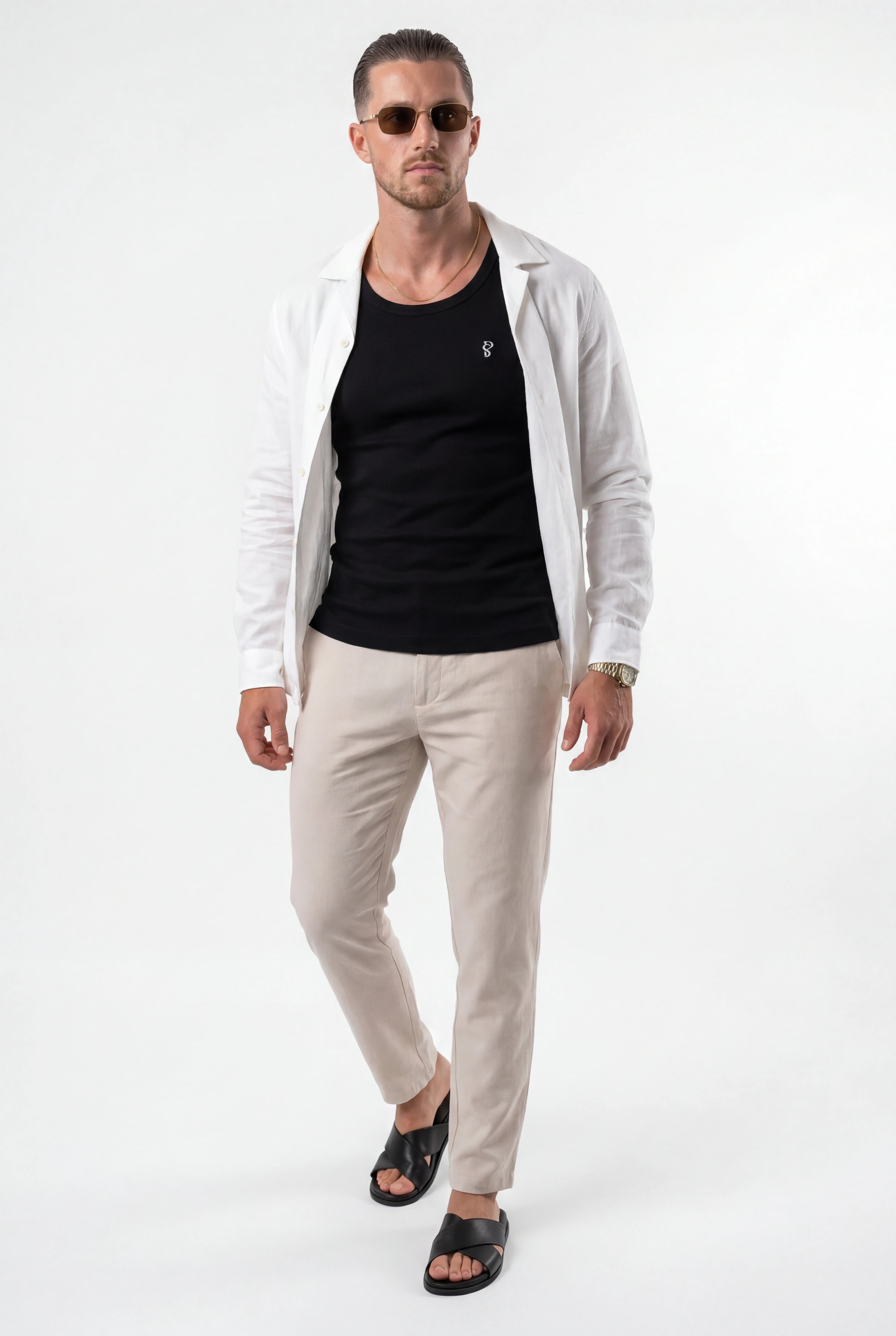 [Black] Man wearing a light gray shirt over a black t-shirt and beige pants on a white background